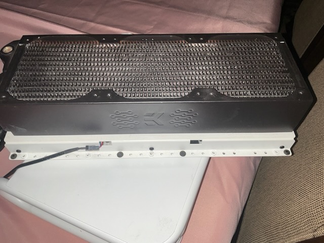 Recovered EK radiator hardware resting on white CaseLabs parts.